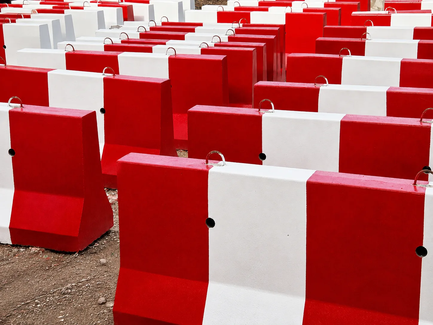 Bulk rows of red and white precast concrete barriers manufactured for UAE projects