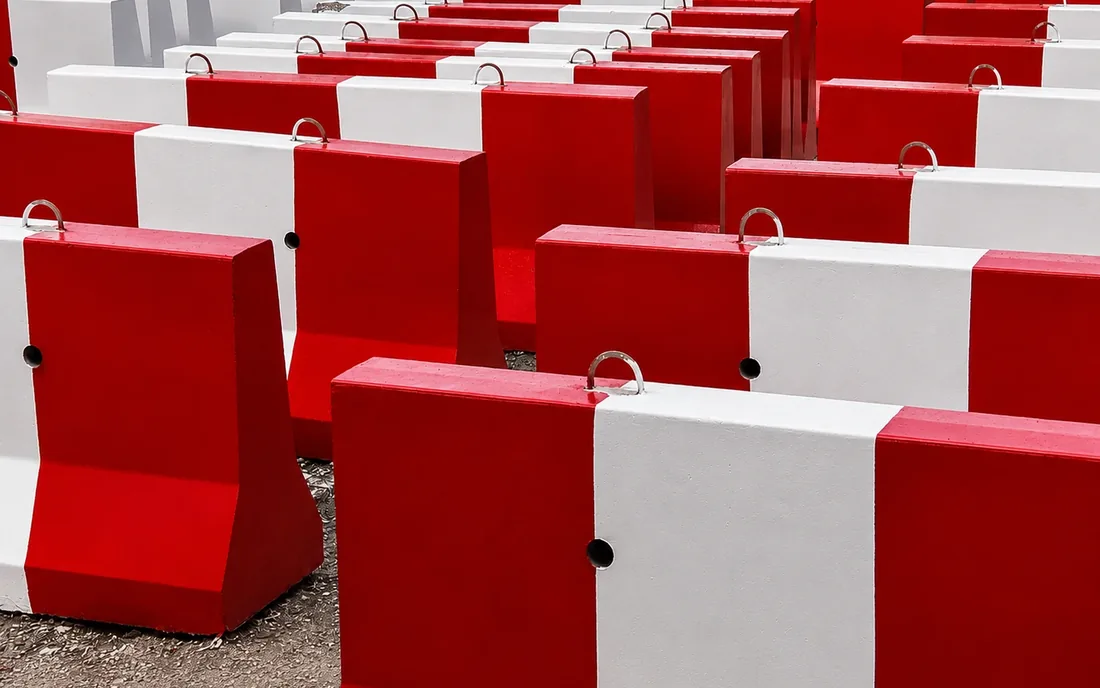 Bulk precast concrete barrier stock in the UAE Bulk rows of red and white precast concrete barriers in a UAE yard