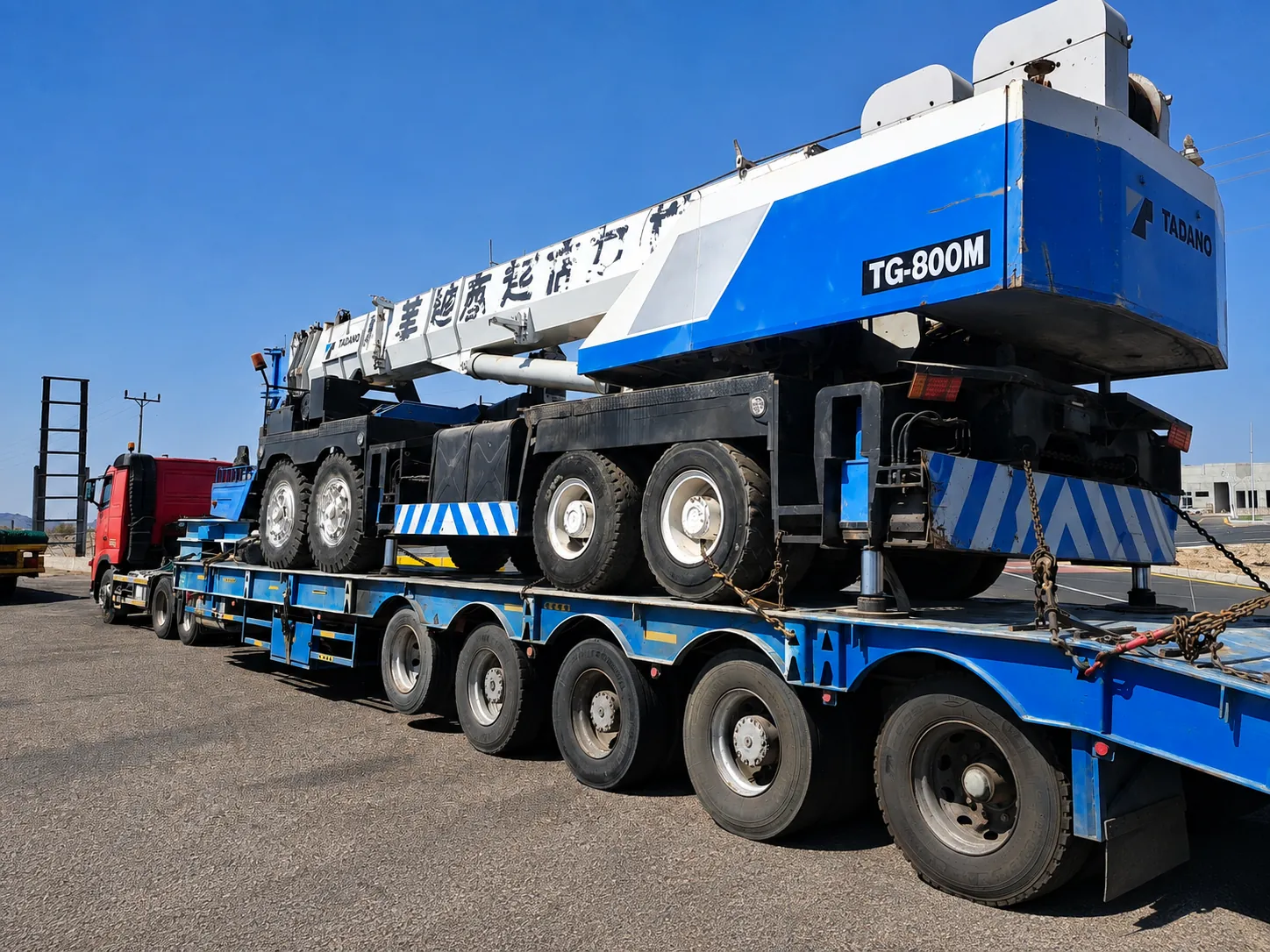 Tadano mobile crane secured on a lowbed trailer for heavy equipment transportation in the UAE