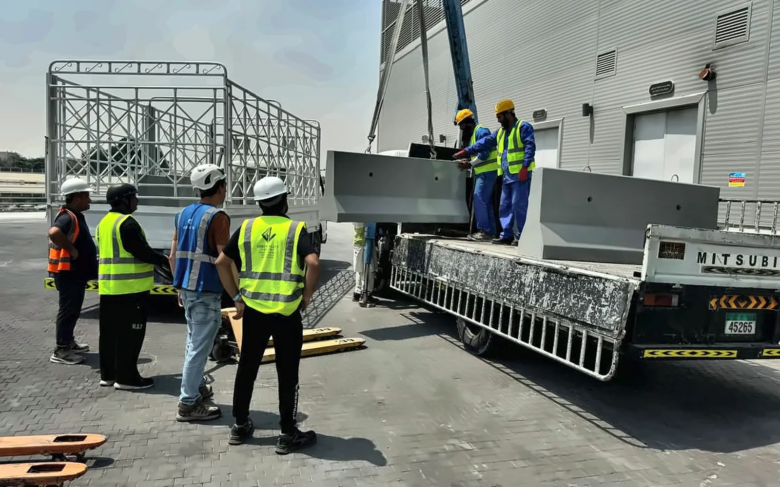 Precast Barrier Offloading and Site Coordination in the UAE Project team coordinating precast barrier offloading from a truck-mounted crane in the UAE