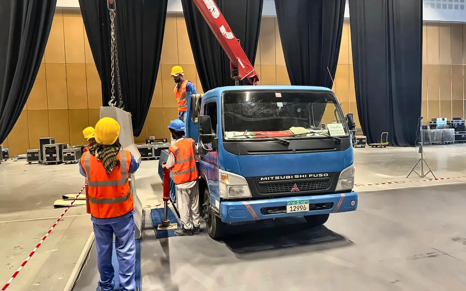 Installation team handling a precast concrete barrier with a truck-mounted crane in the UAE