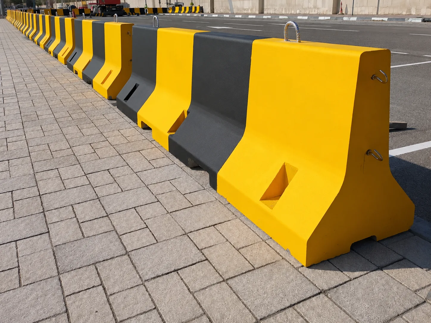 Yellow and black concrete traffic barriers installed along a UAE roadway